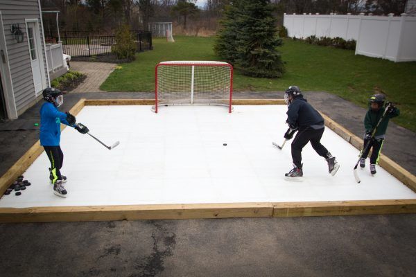 Hockey players improving skills on synthetic ice for backyard training