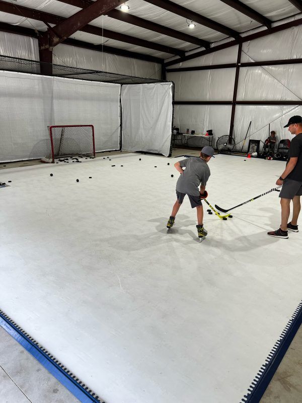 Realize your hockey potential through dedicated training with Skate Anytime synthetic ice in your garage Hockey player practicing on Skate Anytime synthetic ice in garage